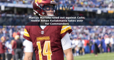 Washington Commanders quarterback Athan Kaliakmanis stands on a football sideline in a burgundy uniform.