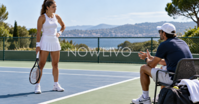 Tennis player listening to a coach at the edge of a court