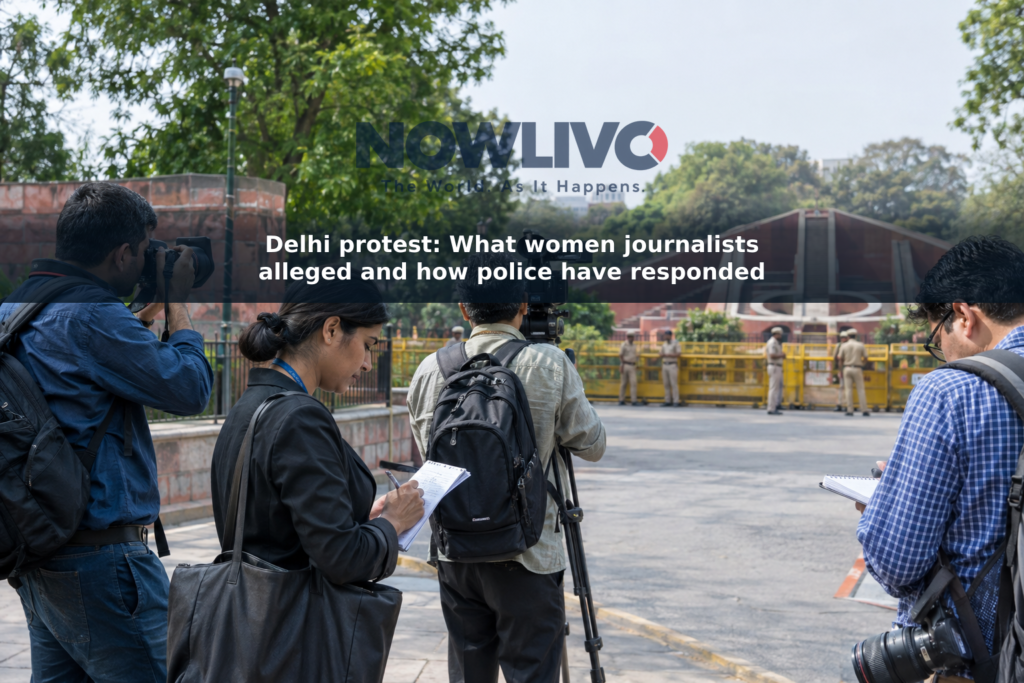Journalists carrying cameras and notebooks near a police barricade in a New Delhi street scene.