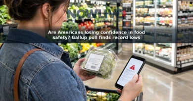 Shopper checks a packaged food’s label while looking at a phone in a grocery store.