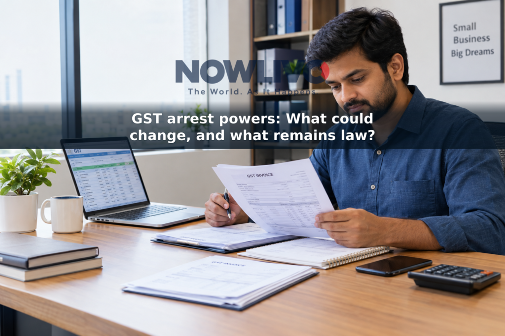 A business owner reviews invoices and a tax spreadsheet at an office desk.