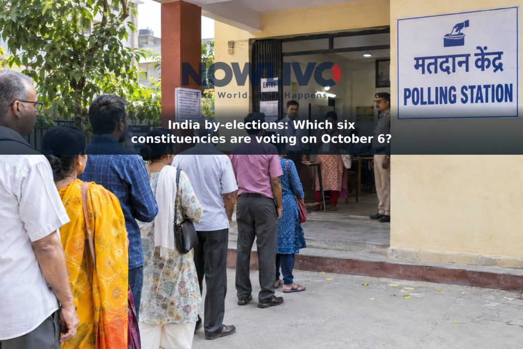 Adult voters queue outside a polling station on an Indian street.