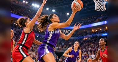 Women basketball players celebrating a close win under arena lights as teammates embrace