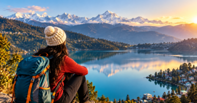 Hiker with a backpack overlooking a mountain lake and distant snowy Himalayan peaks at golden hour